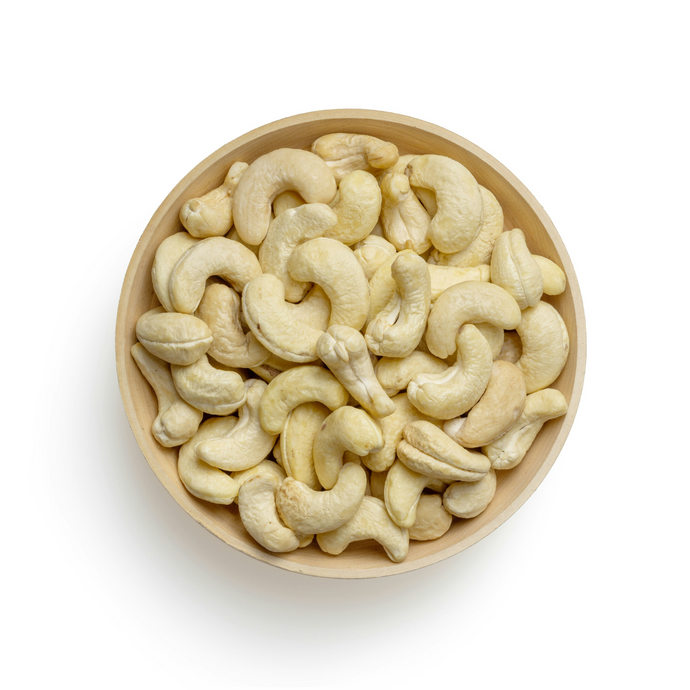 Whole cashew nuts in bowl on white background