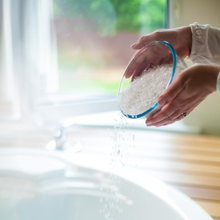 Load image into Gallery viewer, Ladies hands pouring epsom salts from a glass bowl into a bath
