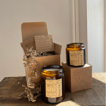 Load image into Gallery viewer, Small and large soy wax candles in amber glass jars with kraft gift boxes.
