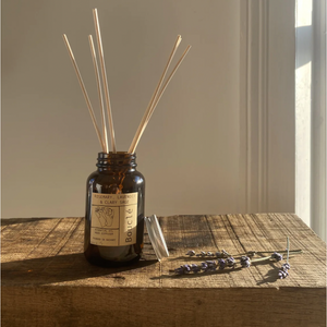 Natural home fragrance: reed diffuser essential oil blend in amber glass jar: rosemary, lavender and clary sage.