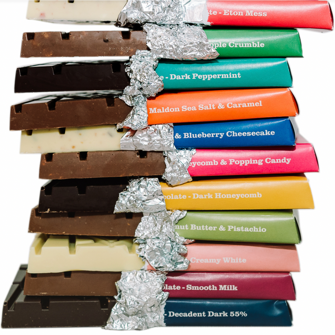 Pile of chunky Temprd chocolate bars with colourful wrapping peeled back to reveal layers of chocolate.