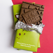 Load image into Gallery viewer, Temprd Chocolate Bar Large - Peanut Butter and Pistachio Milk Chocolate with wrapper peeled back to reveal chunky chocolate.
